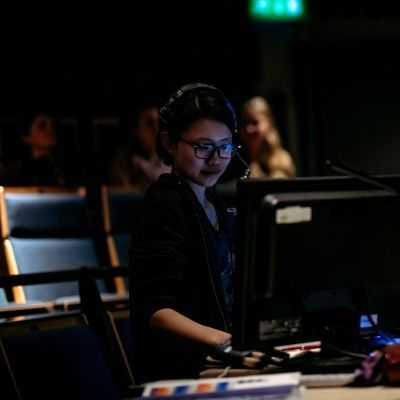 Production Arts student at a lighting desk during a technical rehearsal